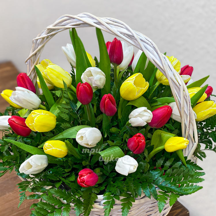 Корзина разноцветных тюльпанов с зеленью (крупный план)